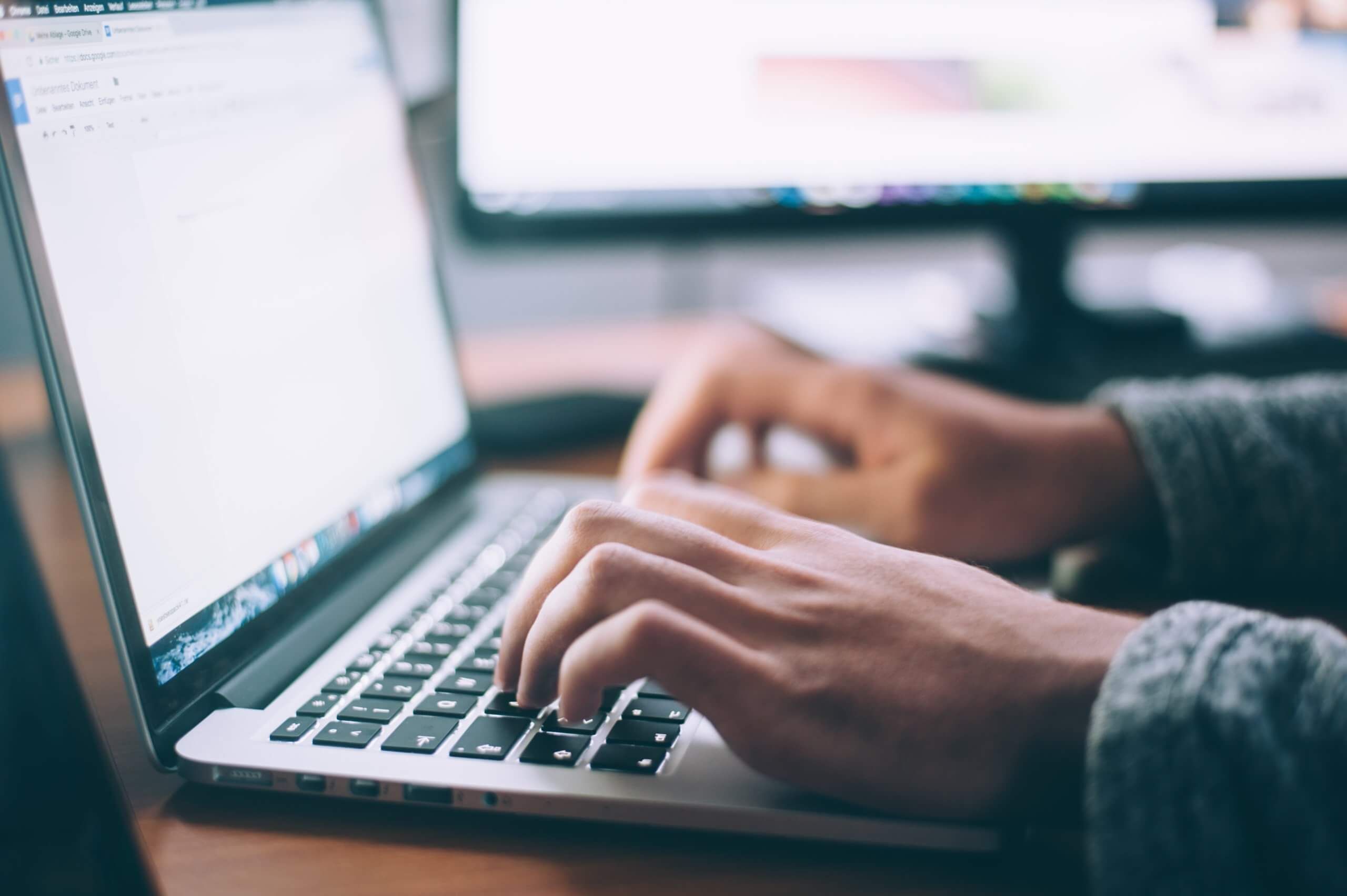 Closeup of businessperson working on laptop