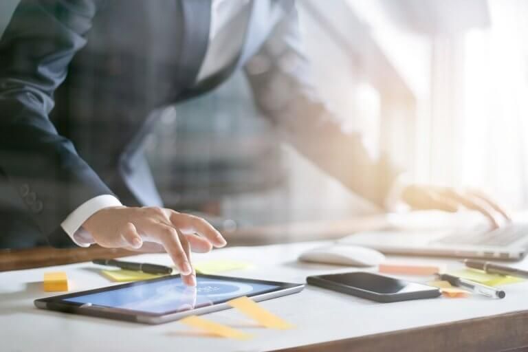 Business person working charts and graphs on tablet and laptop