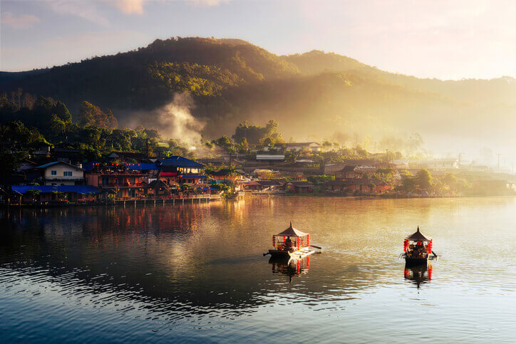 boats on water in front of buildings in thailand